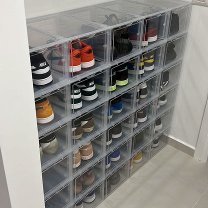 Clear shoe storage boxes with shoes inside in a room.